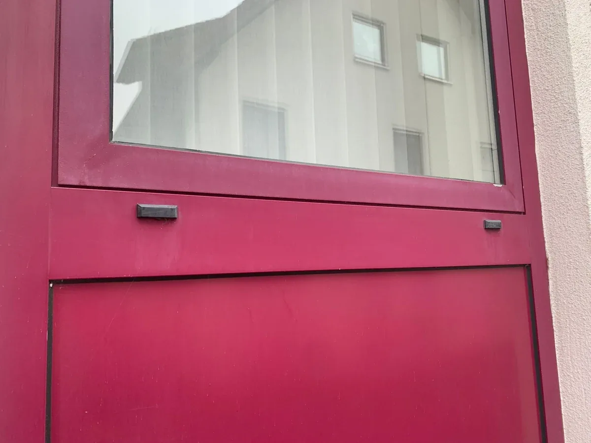 Stumpfe magentafarbene Eingangstür vor der Aufwertung
